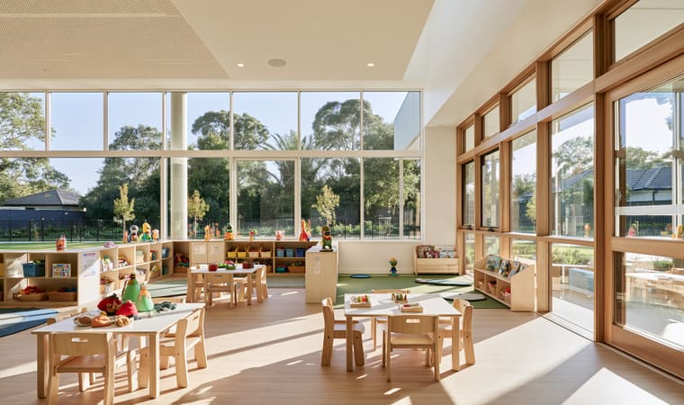 Childcare centre playroom with low tables and toy storage